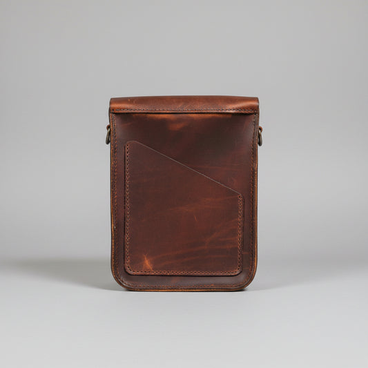 A brown leather crossbody bag with a flap closure and adjustable strap.