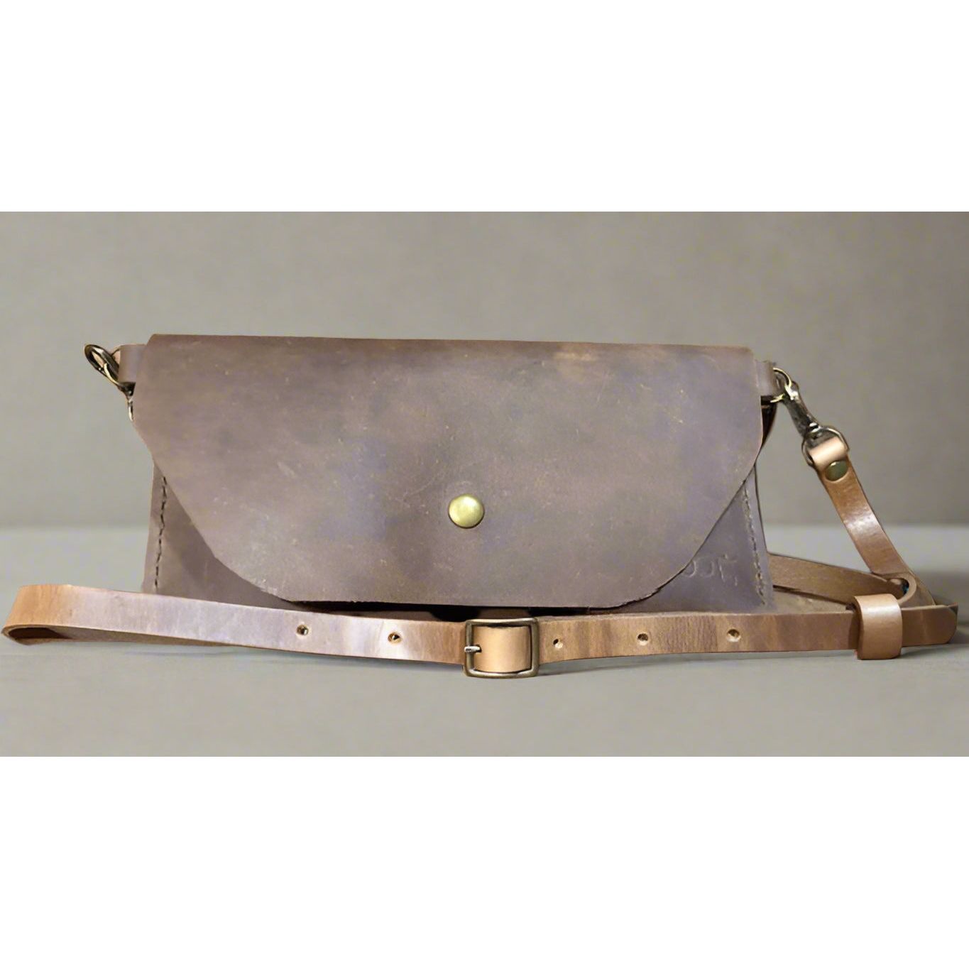Brown leather bag with strap and snap closure